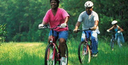 Three people biking outdoors.