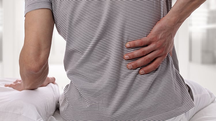 A person holding their lower back.