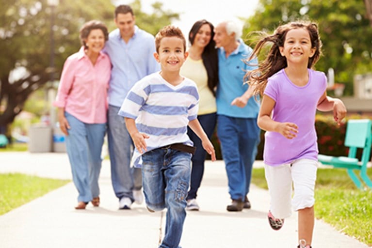Family running together down the sidewalk.