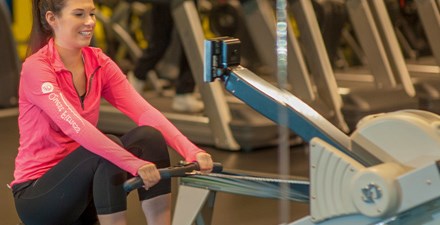 Elizabeth, riding a rowing machine.