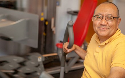 Roberto using strengthing equipment during physical therapy