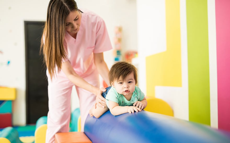 Physical therapist working with an infant on balance