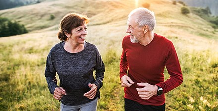 An adult couple enjoying the benefits of exercise outdoors.
