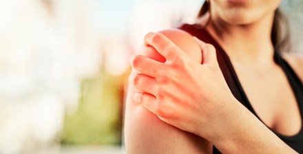 Woman holding shoulder in pain.