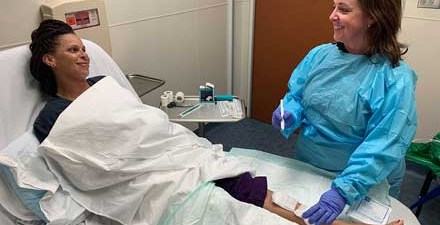 A physical therapist who is a wound care specialist prepares treat a person's  leg wound.