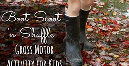 A child in boots shuffles leaves with her feet.