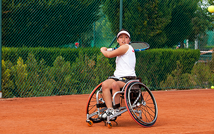 Person in a wheelchair playing tennis